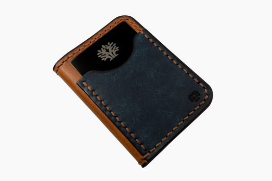 Blue leather wallet with tree logo and brown trim on a white background