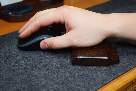 Hand using a black mouse resting on a Lonoke Designs Wenge wrist rest.