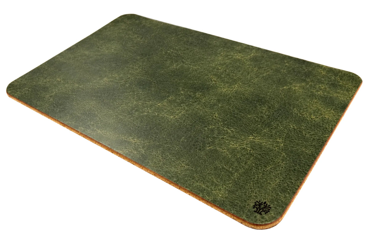 An Emerald green, veg-tanned leather rectangular mouse pad with rounded corners, angled to highlight the cork bottom, featuring a small Lonoke Designs logo in the bottom-right corner, set against a plain white background.
