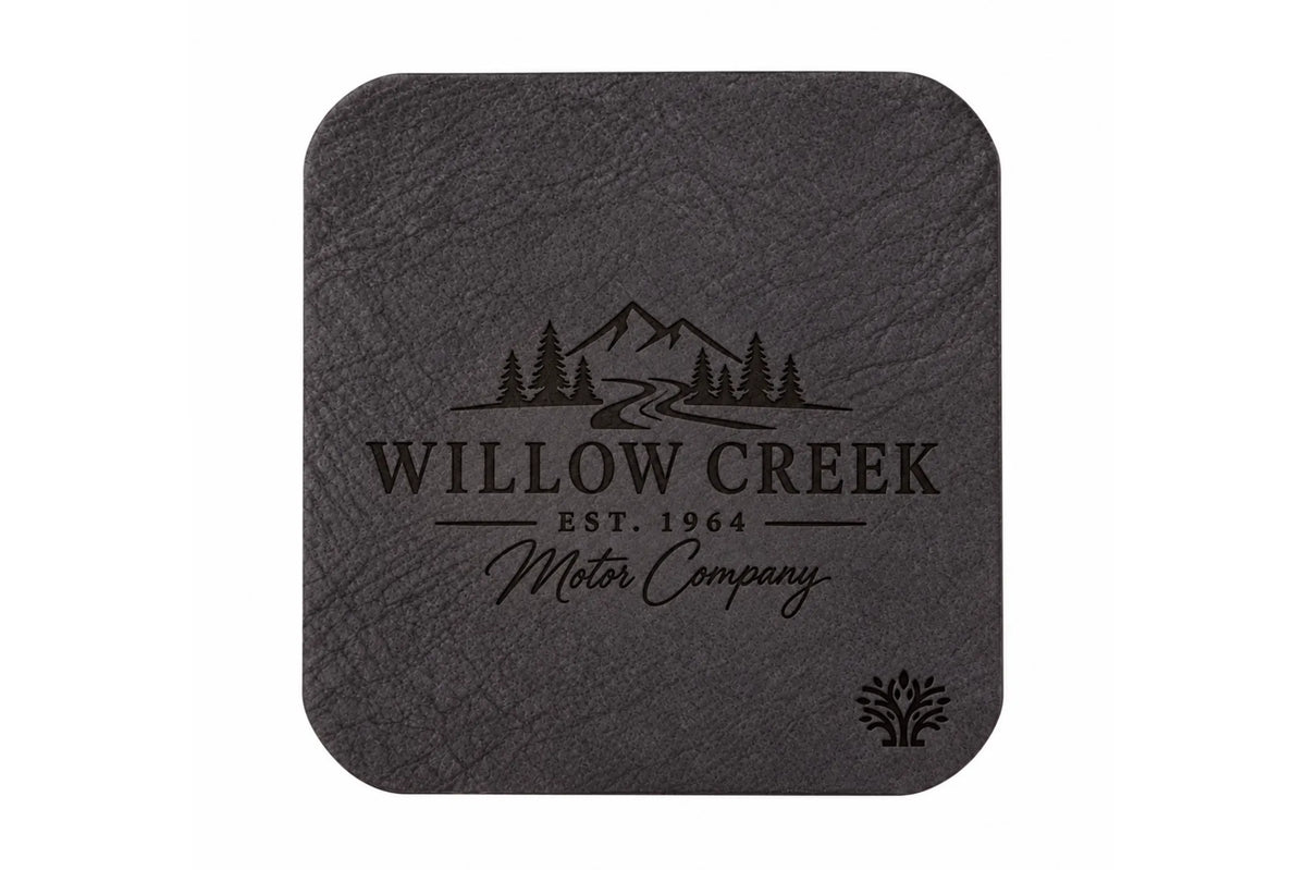 An Espresso darm brown veg-tanned leather square coaster with rounded corners, featuring a small Lonoke Designs logo in the bottom right corner, set against a plain white background. Featuring an example of a company's custom laser engraving.