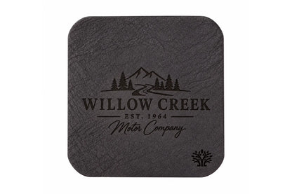 An Espresso darm brown veg-tanned leather square coaster with rounded corners, featuring a small Lonoke Designs logo in the bottom right corner, set against a plain white background. Featuring an example of a company's custom laser engraving.
