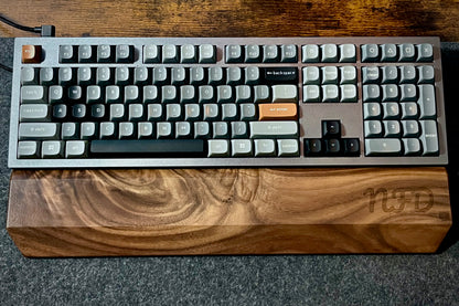 Mechanical keyboard with Walnut keyboard wrist rest, custom-engraved with initials. Sitting on a charcoal, wool felt and cork desk pad. Handcrafted and laser-engraved in-house at Lonoke Designs.