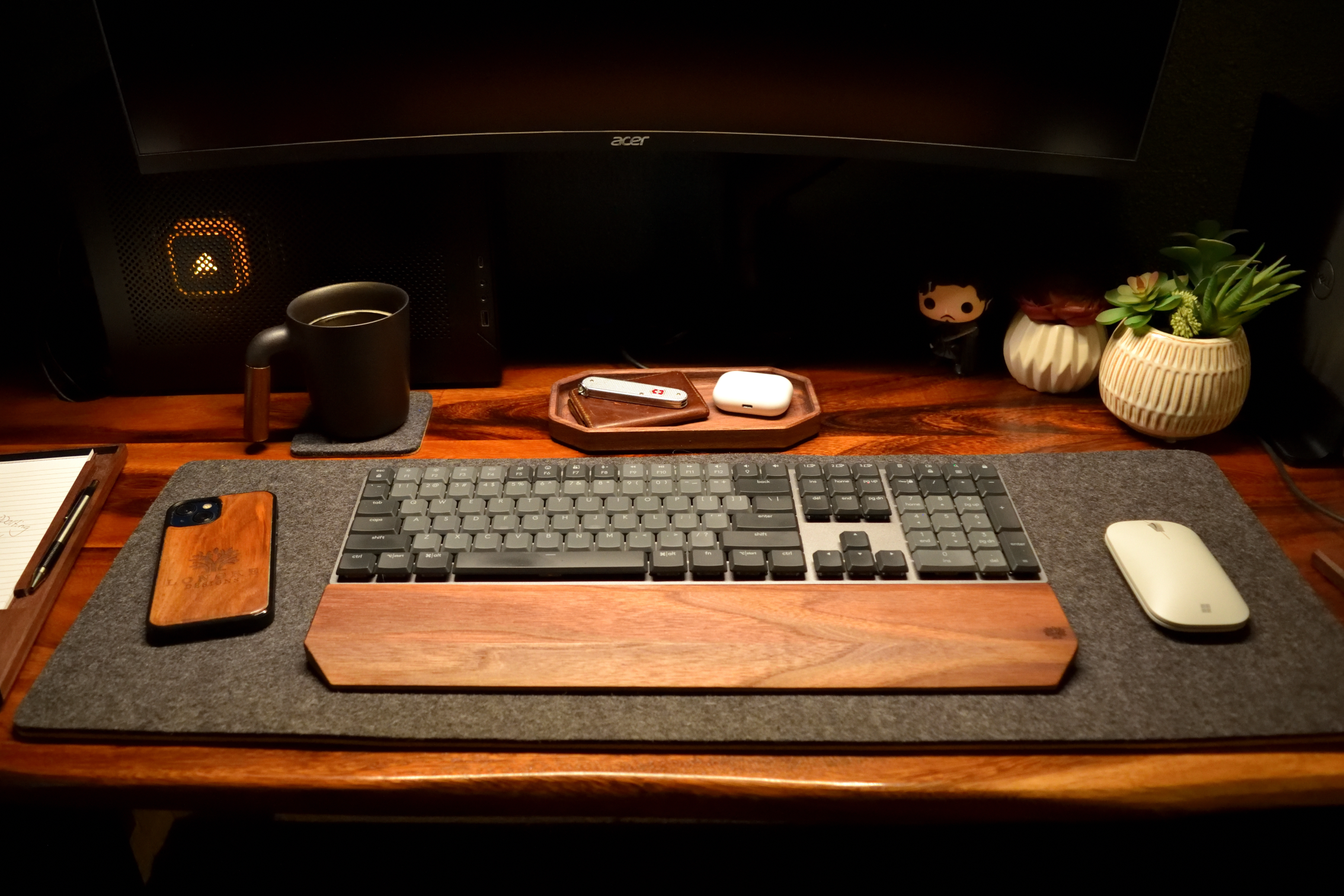 Wooden desk setup with keyboard, mouse, phone, and Acer monitor.