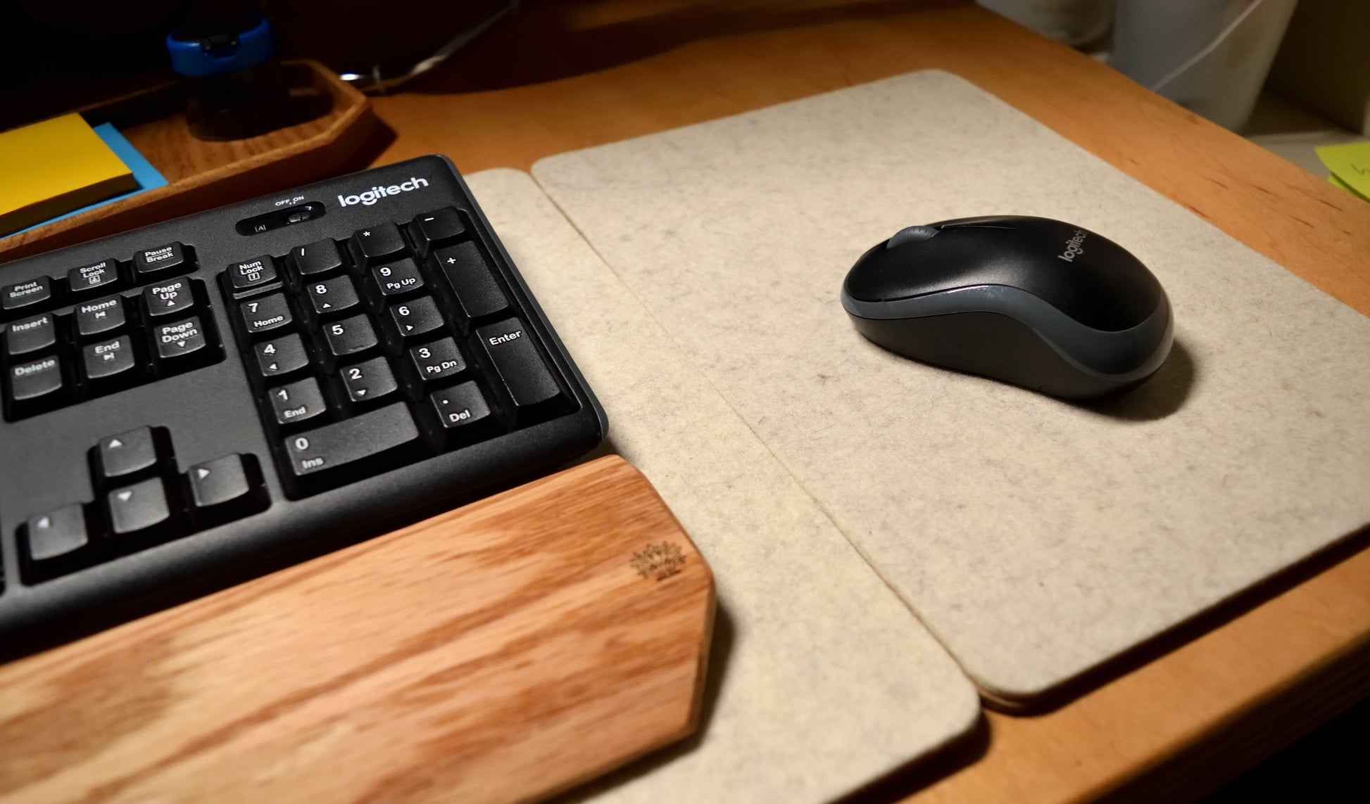 Keyboard and mouse on a desk with a wool mouse pad