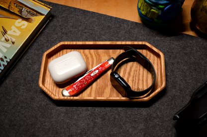 Wooden tray with Apple Air Pods, red Case pocket tool, and black Apple Watch in a oak organizer tray.