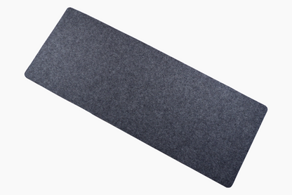A rectangular shadow gray desk pad made of wool felt and cork, designed for use on a desk.