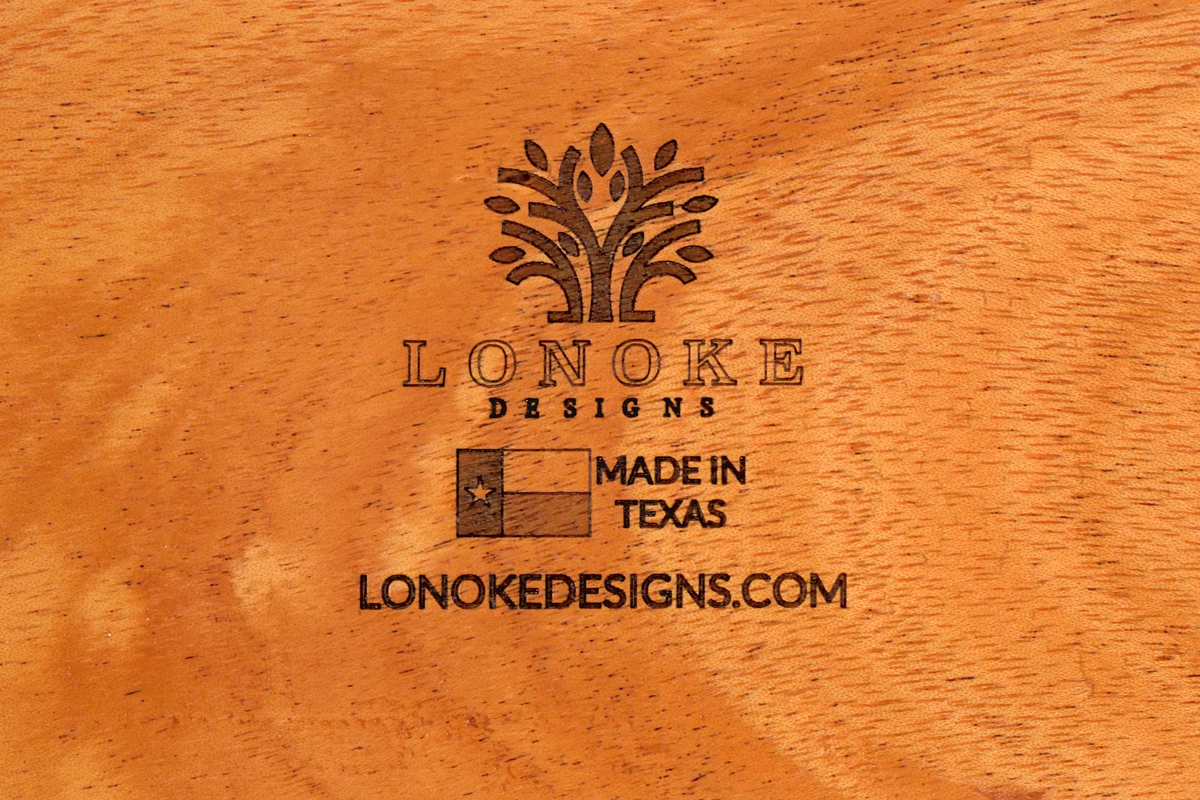 Mahogany wooden surface with 'Lonoke Designs' logo and 'Made in Texas' text with Texas Flag.
