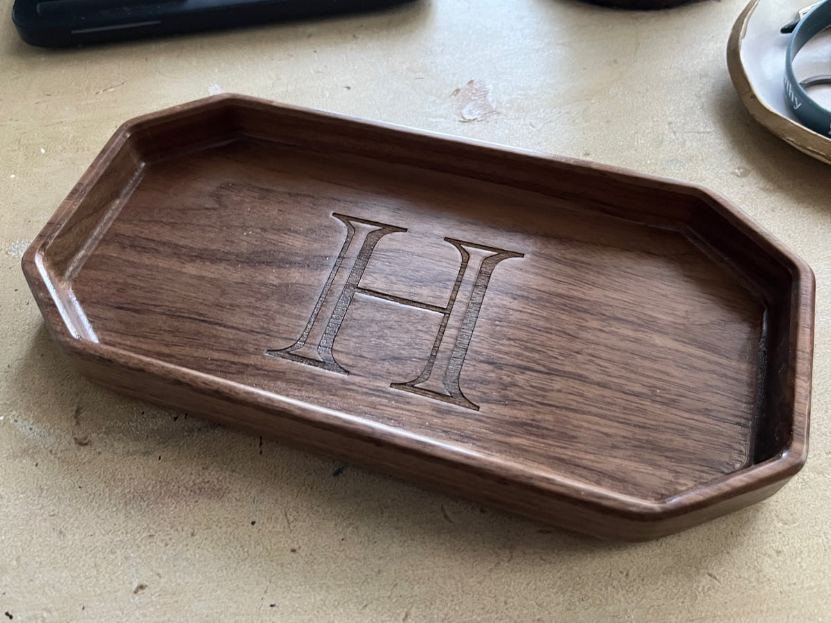 Lonoke Designs walnut hardwood catchall tray with 'H' engraving on a light-colored table