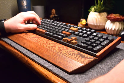 Person using a mechanical keyboard on a wooden desk with a dark background