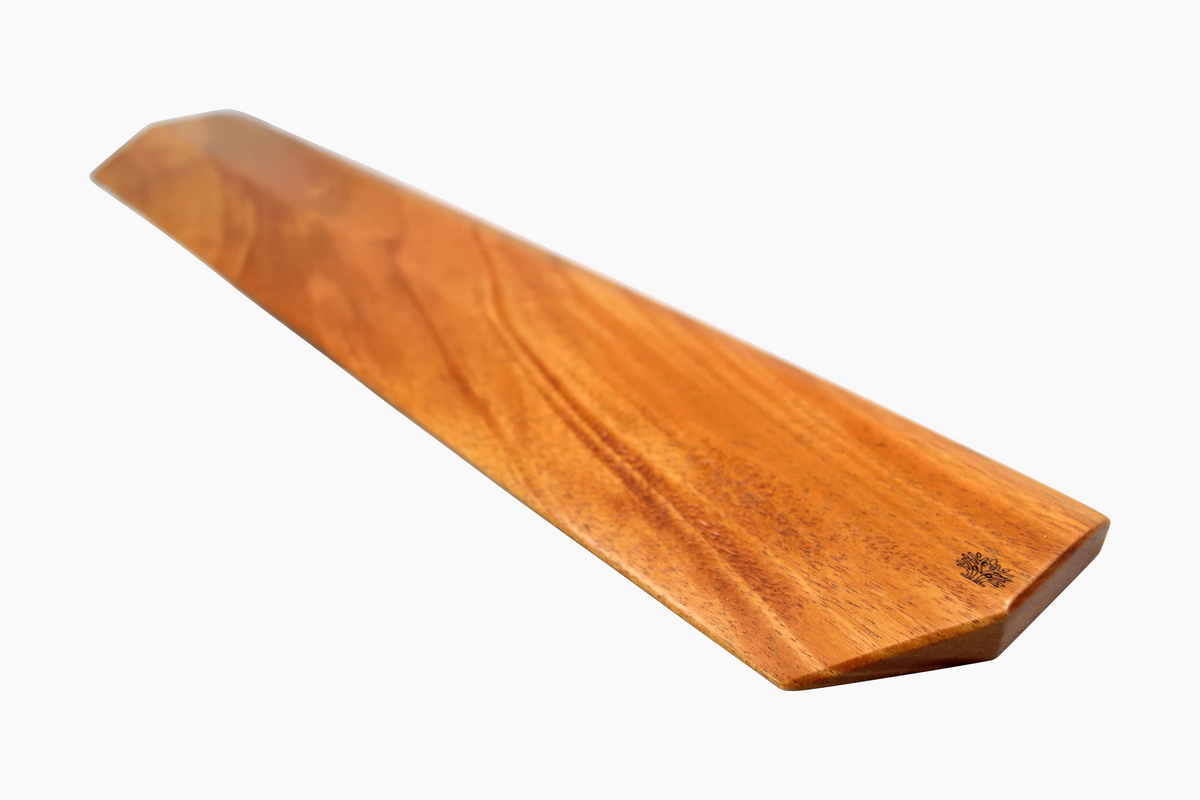 A Lonoke Designs Mahogany wood mechanical keyboard wrist rest from a side angle on a solid white background.