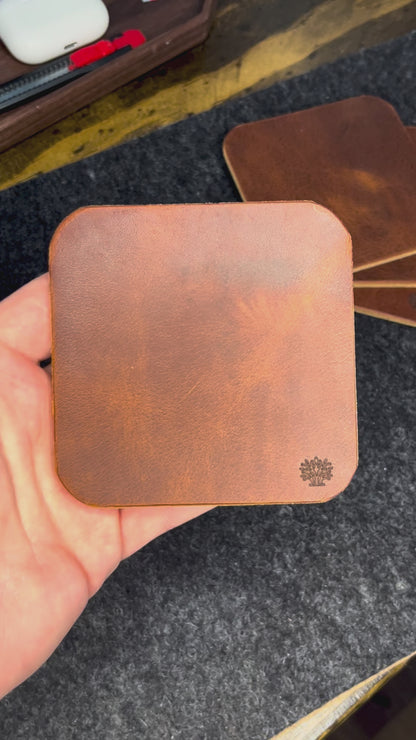 A video of the Lonoke Designs leather coasters being showcased on a charcoal wool felt and cork desk pad.