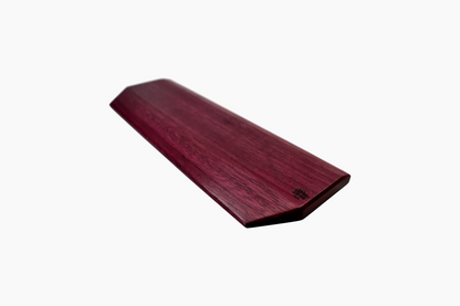 Side angle of handmade Lonoke Designs Purpleheart hardwood wrist rest, showing smooth finish and natural wood grain.